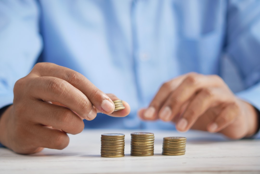 una persona apilando monedas encima de una mesa